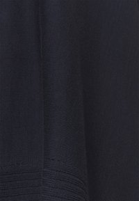 Tessuto a maglia blu navy con un motivo a coste testurizzato e una leggera lucentezza. Finitura liscia con una caduta leggermente morbida.