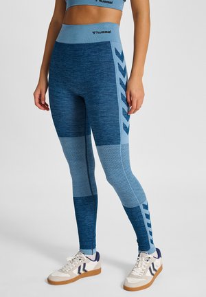 Niebieskie legginsy o fakturowanym wzorze, z różnymi odcieniami niebieskiego, panelami z siateczki oraz akcentami w kształcie jodełki po bokach.