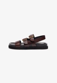 Brown leather sandals with a minimal design, featuring two adjustable straps and a rear strap. They have a black rubber sole for traction.