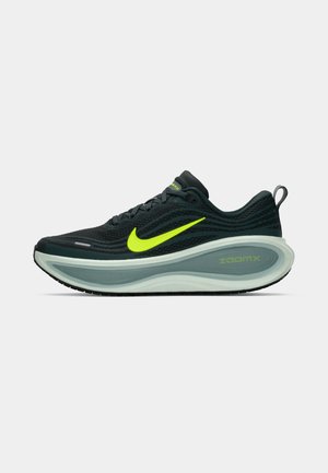 Sort og neon grøn Nike løbesko med tykk ZoomX sål, snørebåndslukning og trækstrop på hælen, vist fra siden på en hvid baggrund.