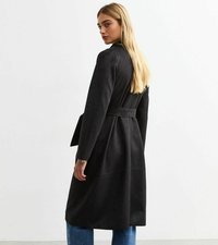 Svart mockakappa med bälte i midjan, strukturerade axlar och lagerdesign. Modellen visas bakifrån mot en ljus bakgrund.