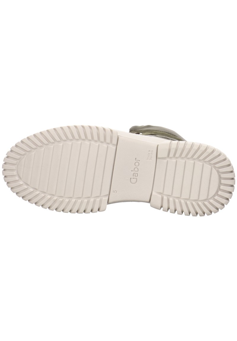 Gummisohle mit geriffelter Textur, weißer Farbe und Markenlogo auf der Mittelsohle. Verfügt über eine glatte, matte Oberfläche.