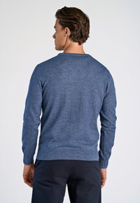 Dunkelblau gestrickter Pullover mit langen Ärmeln, rundem Halsausschnitt und subtiler Textur; taillierte Passform mit gerippten Bündchen und Saum.