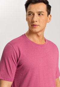T-shirt a girocollo rosa realizzato in un morbido mix di cotone, con maniche corte e una texture liscia, ideale per un abbigliamento casual.