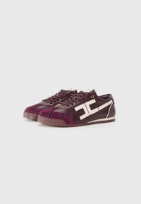 Maroon sneakers with leather and suede materials, featuring a rounded toe, contrasting white logo, lace-up design, and rubber soles.