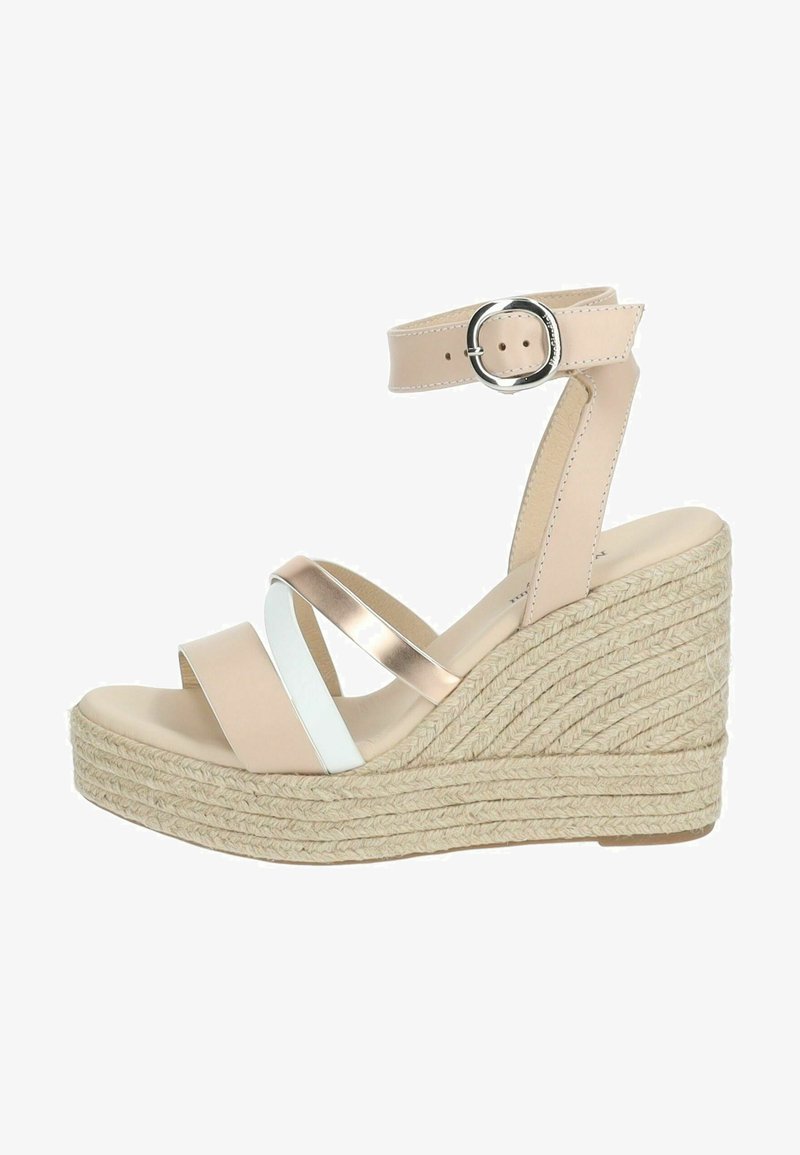 Sandale compensée beige avec une semelle en espadrille, présentant des brides entrecroisées en rose doré métallisé et blanc, ainsi qu'une bride à la cheville avec boucle.