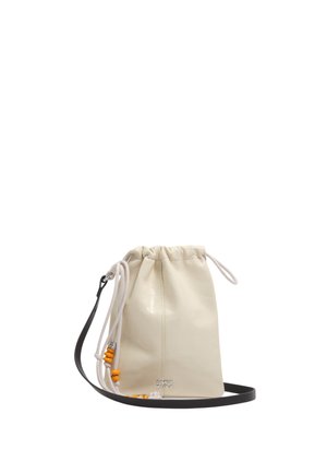 Bolsa de saco color crema con cordones blancos y cuentas naranjas, correa negra para llevar cruzada y pequeño logo metálico "Bimba y Lola" en la base.