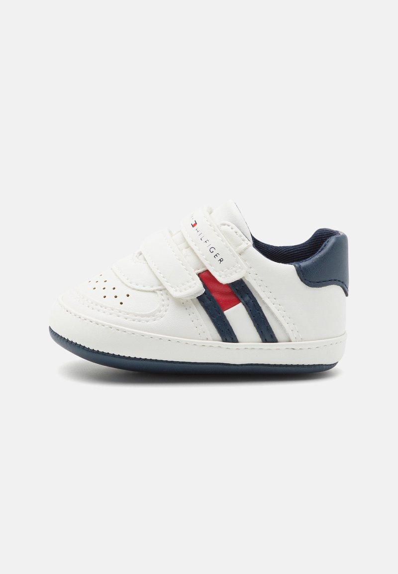 Baskets blanches pour tout-petit avec des rayures bleu marine et rouge, deux sangles à scratch et un col de talon rembourré bleu marine.