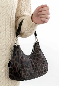 Leopardimustriga käekott mustade aksentide, siledapinnalise tekstuuri ja läikivate kaunistustega. Kumer kuju eemaldatava õlarihmaga.