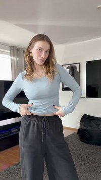 Világoskék, hosszú ujjú felső testhezálló szabással, laza fekete melegítőnadrággal párosítva, mely elasztikus derékpánttal és húzózsinórral rendelkezik.