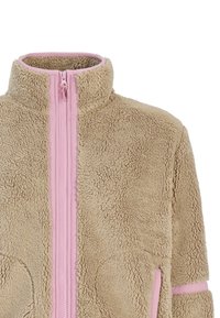 Veste en polaire beige avec une fermeture éclair rose, un col montant bordé de rose et des poches bordées de rose, présentant un tissu texturé et duveteux.