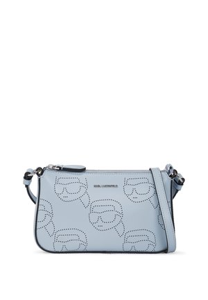 Light blue leather bag featuring cutout designs, a zip closure, and a detachable shoulder strap. Accented with a logo and subtle texture.