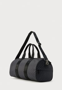 Μαύρη σακίδιο duffel με υφασματικό σχέδιο λογότυπου, διπλές λαβές και ρυθμιζόμενο λουρί ώμου. Κομψός σχεδιασμός με αντιθετικές μαύρες λεπτομέρειες.