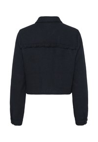 Izgriezta melna jaka ar teksturētu herringbone rakstu, apkakli un ruffles detaļu aizmugurē. Garas piedurknes ar pogu aprocēm.