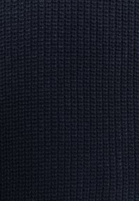 Dunkelblauer, gestrickter Stoff mit einer strukturierten, gerippten Oberfläche, die ein dichtes Gewebe und ein weiches Aussehen zeigt, ideal für Bekleidung oder Accessoires.
