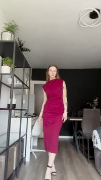 Testre szabott bordó ruha aszimmetrikus dekoltázzsal és midi hosszúsággal. Simább anyag, elegáns vonalakkal, fekete magassarkú szandálokkal párosítva.
