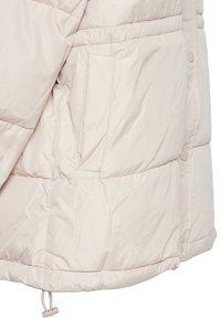 Svetlobéžová prešívaná bunda s bočnou vreckom, cvokovými gombíkmi a nastaviteľným sťahovaním v spodnej časti.