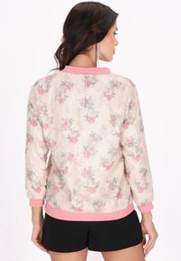 Blommig bomberjacka i blusherosa med texturerat tyg, som har ett paljettmönster, långa ärmar och en ribbad krage och manschetter i rosa.