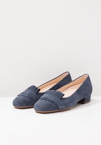 Scarpe flat in suede blu navy con punta arrotondata, caratterizzate da un accento plissettato e una fascia testurizzata nella parte anteriore. Tacco basso e robusto.