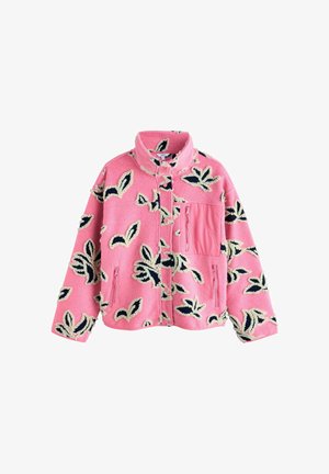 Rozā flīsa jaka ar ziedu rakstu melnā un krēmkrāsā. Aprīkota ar augstu apkakli, priekšējo rāvējslēdzi un vairākiem kabatām. Ar strukturētu virsmu.