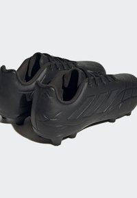 Botas de fútbol negras con un upper de cuero liso, que cuentan con patrones de rayas diagonales, cierre de cordones y tacos moldeados para tracción.