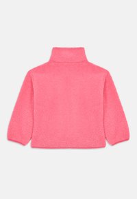 Pull en polaire de couleur rose vif avec un col haut, des manches longues et une surface douce et texturée. Pas de fermetures ou de motifs visibles.