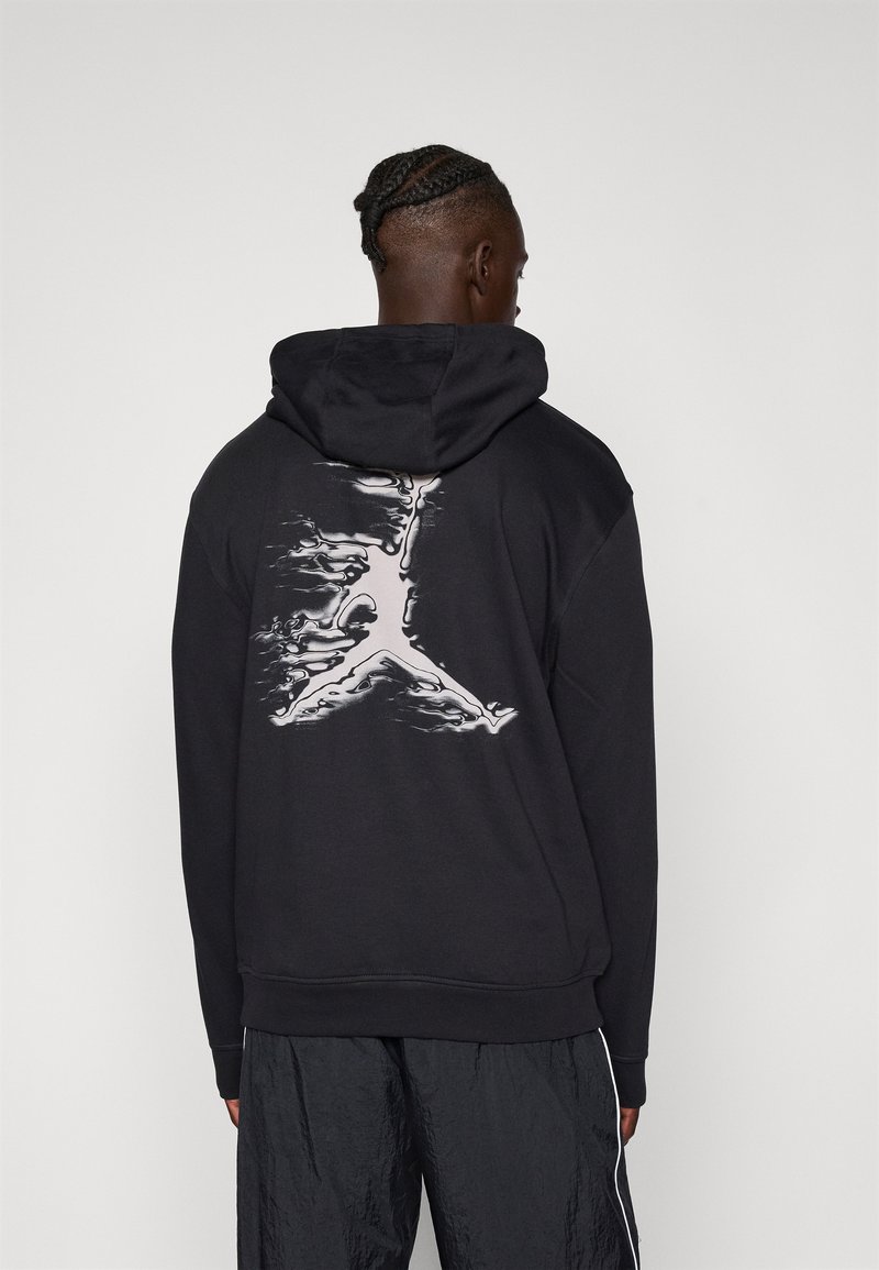 Sort hættebluse med et stort hvidt Jumpman-logo på ryggen. Lavet af et blødt stof med en afslappet pasform og snoretræk i hætten.