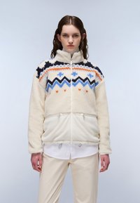 Fleece-pullover i creme med multicolorerede geometriske og zigzag mønstre. Har høj krave, for-lynlås og justerbar snor i kanten.