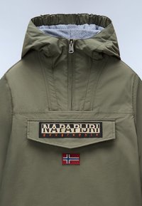 Olivegrüner Anorak-Jacke mit Reißverschluss, elastischer Kapuze und Logo-Patch mit Akzent der norwegischen Flagge. Leichter Stoff mit einer glatten Textur.