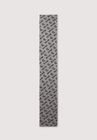 Banner din material textil gri, cu inscripții repetate în negru ale cuvântului "just" și o literă "t" stilizată, evidențiind o textură netedă și un design vertical.