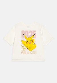 Camiseta blanca con un gran gráfico de Pikachu en amarillo, "0025" en rosa y "PIKACHU" en una fuente brillante. Mangas cortas, corte holgado.