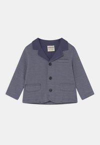 Granatowa marynarka wykonana z textured materialu, z wykładanym kołnierzem, trzema guzikami i dwiema przednimi kieszeniami.