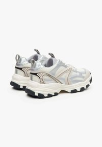 Sportowe sneakersy z górną częścią z siateczki w kolorach srebrnym i kremowym, czarną gumową podeszwą oraz kontrastującymi beżowymi akcentami. Wyposażone w uchwyty do łatwego zakładania.