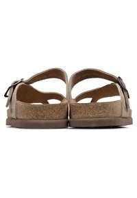 Sandales en suède marron avec une semelle en liège, dotées de deux larges brides et d'une boucle ajustable. Semelle texturée et accents brun clair.