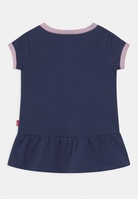 Navy cotton dress with short sleeves, pink ribbed neckline, and gathered ruffle at the hem. Tag visible on the side. Soft texture.