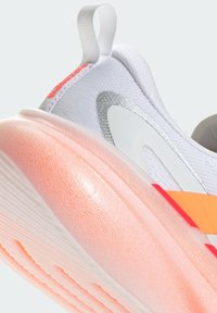 Scarpa da ginnastica con tomaia in tessuto bianco, dettagli riflettenti e suola esterna traslucida rosa. Presenta un anello per il trascinamento e una striscia arancione audace.