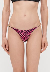 Rožinės ir juodos zebro rašto bikini kelnaitės su plonomis šoninėmis raištelėmis, puošiančiomis akcentais, pagamintos iš tamprios medžiagos patogumui.