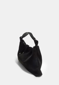 Sort ruskind handbag med en blød tekstur, en knyttet rem og en unik, konisk form. Har sølvdetaljer på lukningen.