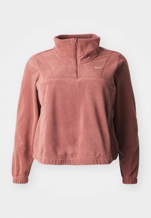 Długi różowofioletowy polarowy sweter z półzamkiem z przodu, wysokim kołnierzem, elastycznymi mankietami i małym białym logo Nike na lewej piersi.