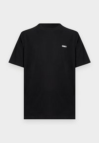 Μαύρο t-shirt με κοντά μανίκια και στρογγυλή λαιμόκοψη, με μικρό λευκό λογότυπο "OBEY" στο αριστερό στήθος, σε απλό ανοιχτό γκρι φόντο.