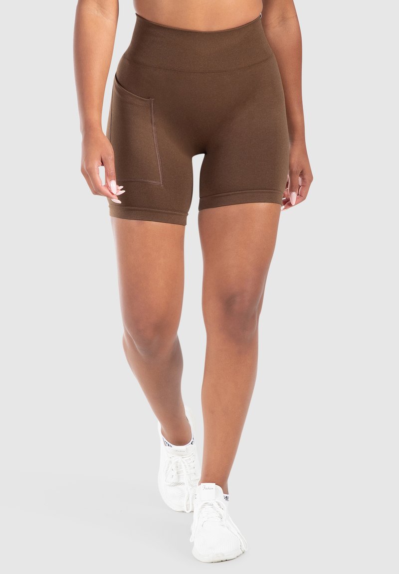 Shorts marroni a vita alta con finitura testurizzata, dotati di tasca laterale e design alla lunghezza del ginocchio. Abbinati a scarpe sportive bianche.
