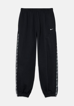 Zwarte joggingbroek met elastische tailleband, taps toelopende boorden en wit Nike-logo. Heeft zijstrepen met een patroon van herhaalde "Nike"-tekst.
