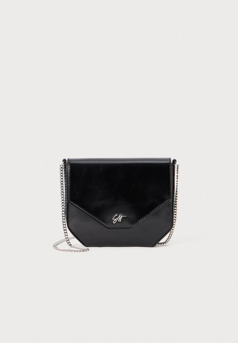Borsa a tracolla nera in pelle con forma geometrica, tracolla in catena argentata e logo impresso sul davanti. Finitura liscia e design minimalista.