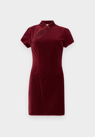 Rochie din catifea bordeaux cu guler înalt, mâneci scurte și detaliu decorativ sub formă de nod la decolteu. Textură fină, siluetă ajustată.