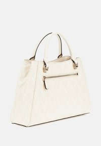 Beige Handtasche mit einem Zickzack-Steppmuster, zwei oberen Tragegriffen, einer vorderen Reißverschlusstasche und Beschlägen in Goldoptik.