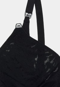 Black lace bra featuring a textured pattern, adjustable straps, and metal hardware for closure. Smooth, intricate detailing on fabric.