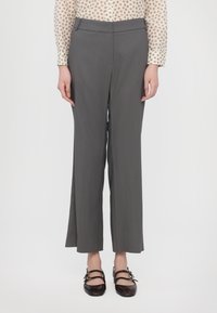 Gray, wide-leg trousers with a smooth texture, featuring a fitted waistband and side pockets. Paired with black, strap shoe.