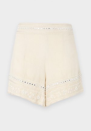 Pantaloni corti color crema con una cintura ricamata e accenti decorativi, caratterizzati da un orlo scallop e intricati motivi floreali.
