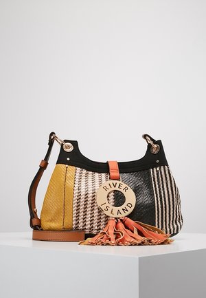Torba na ramię z wzorem patchwork w żółtych, czarnych i beżowych kolorach, z okrągłą zawieszką River Island i pomarańczowym detalem z frędzli.