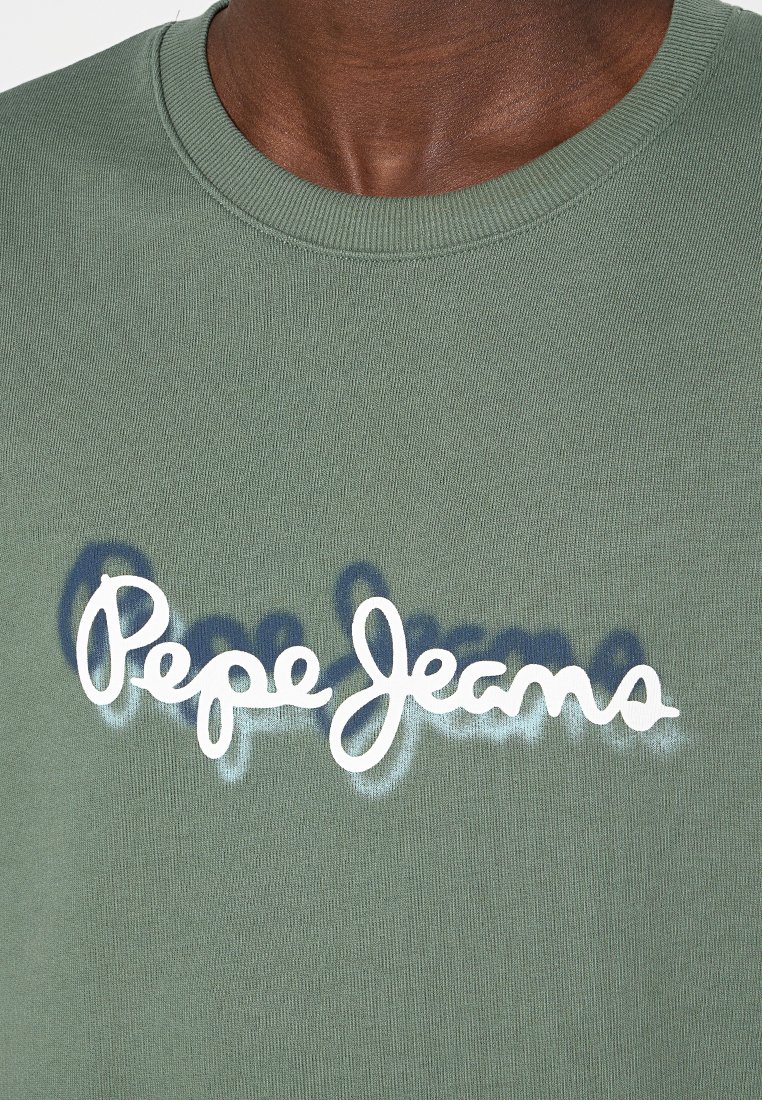 Personne à la peau foncée portant un sweat-shirt olive à col rond avec le logo blanc "Pepe Jeans" et un effet d'ombre à l'avant.